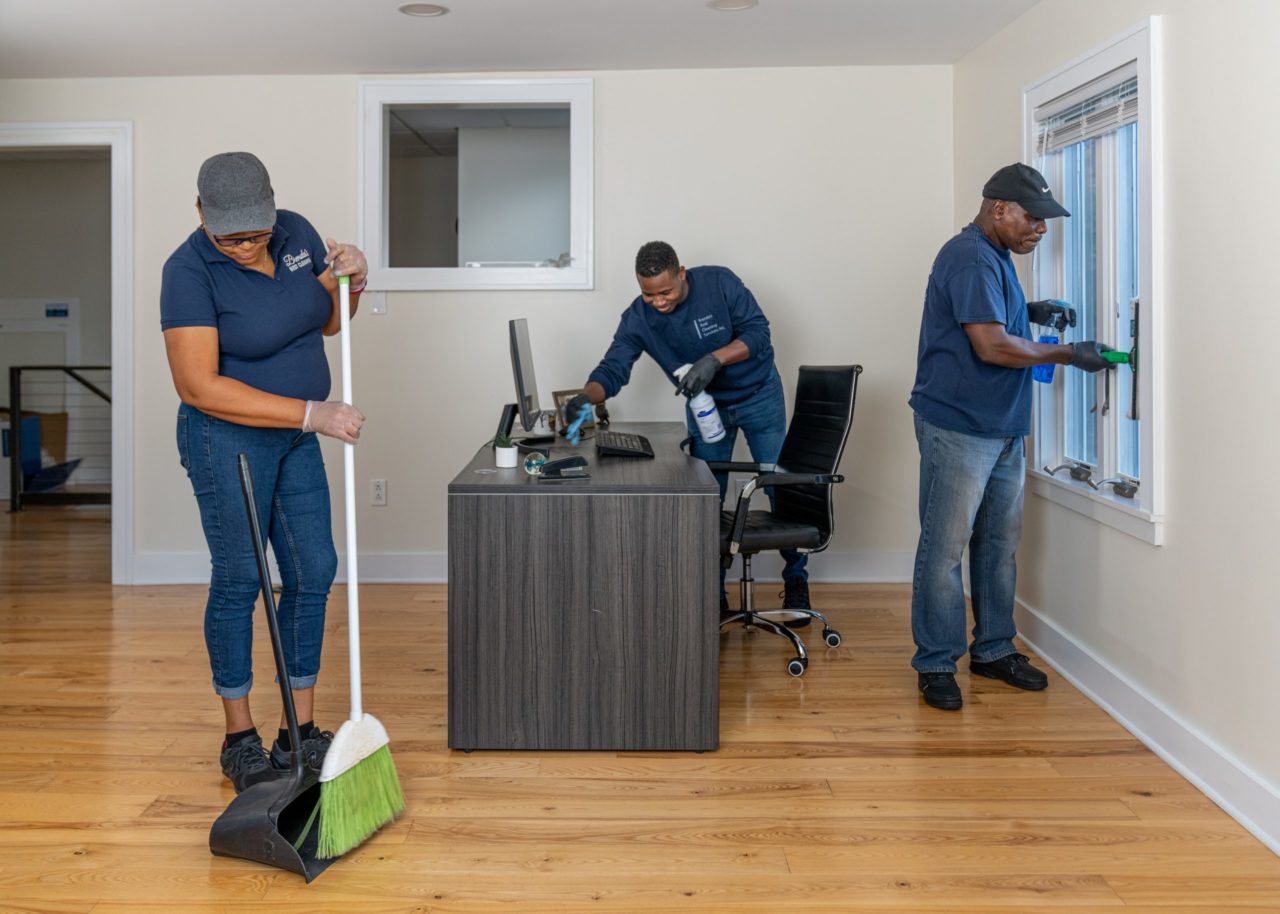 3 commercial cleaners cleaning an office space